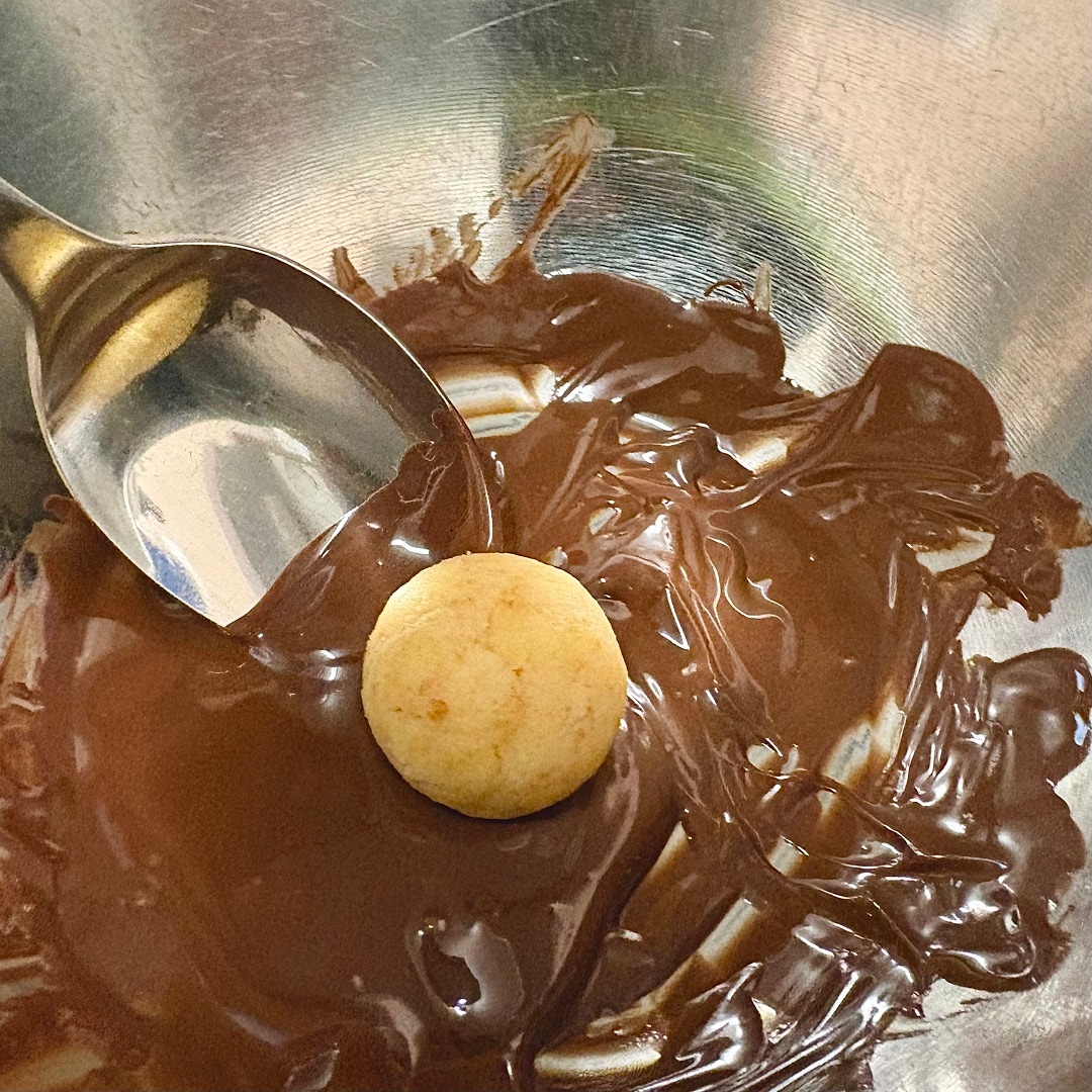 手でまるめた生地に溶かしたチョコレートを絡めるイメージ画像