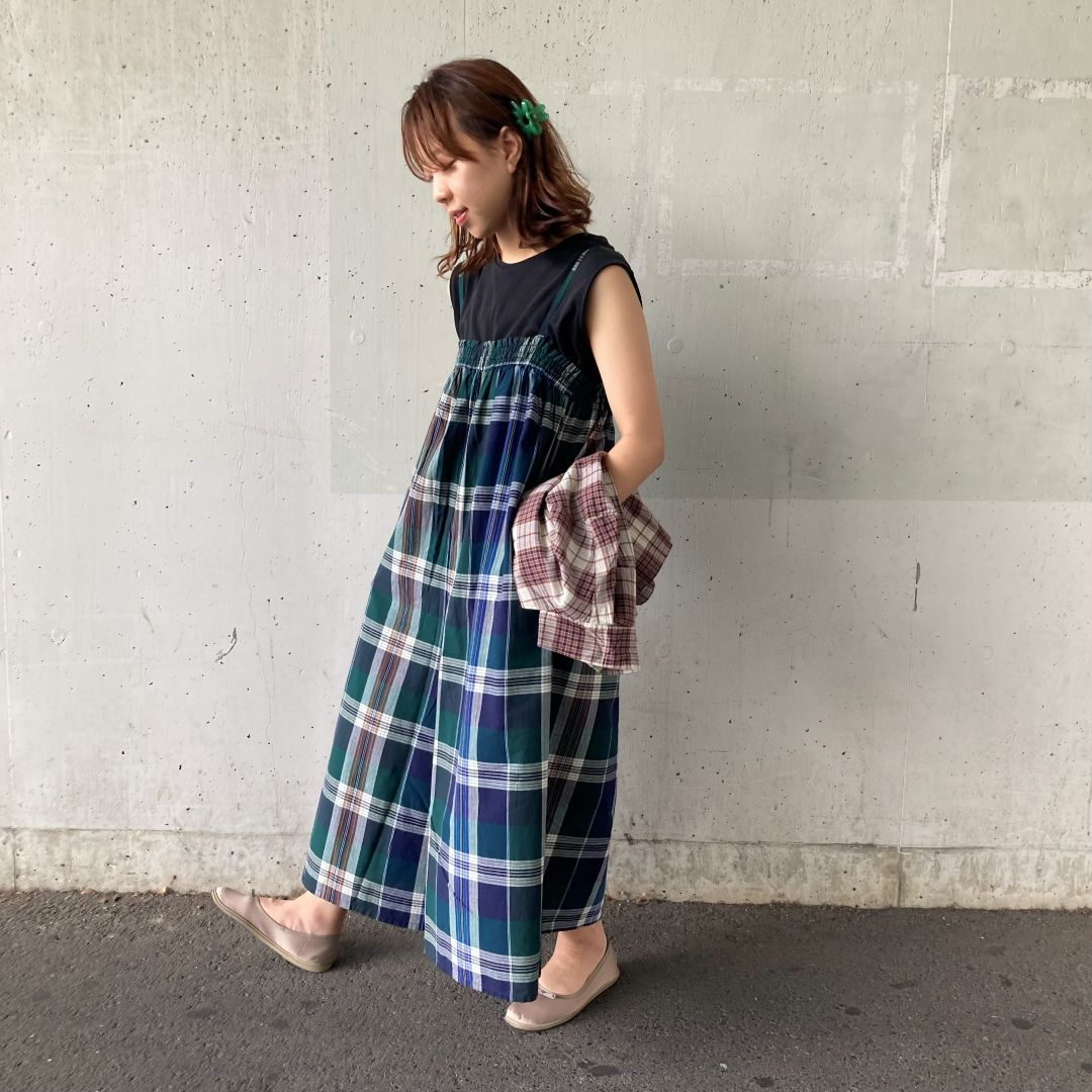 マドラスチェックのサロペットを着用した女性