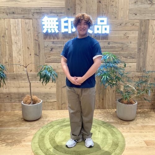 ネイビーの半袖Tシャツを着て立つ男性