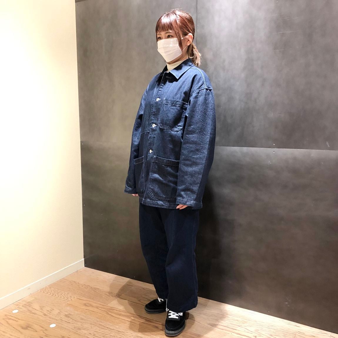 カバーオール着用の女性スタッフ斜め向き