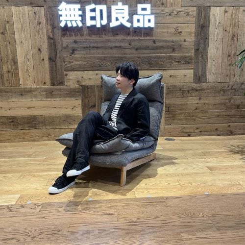 リネン素材のセットアップを着て椅子に座る男性