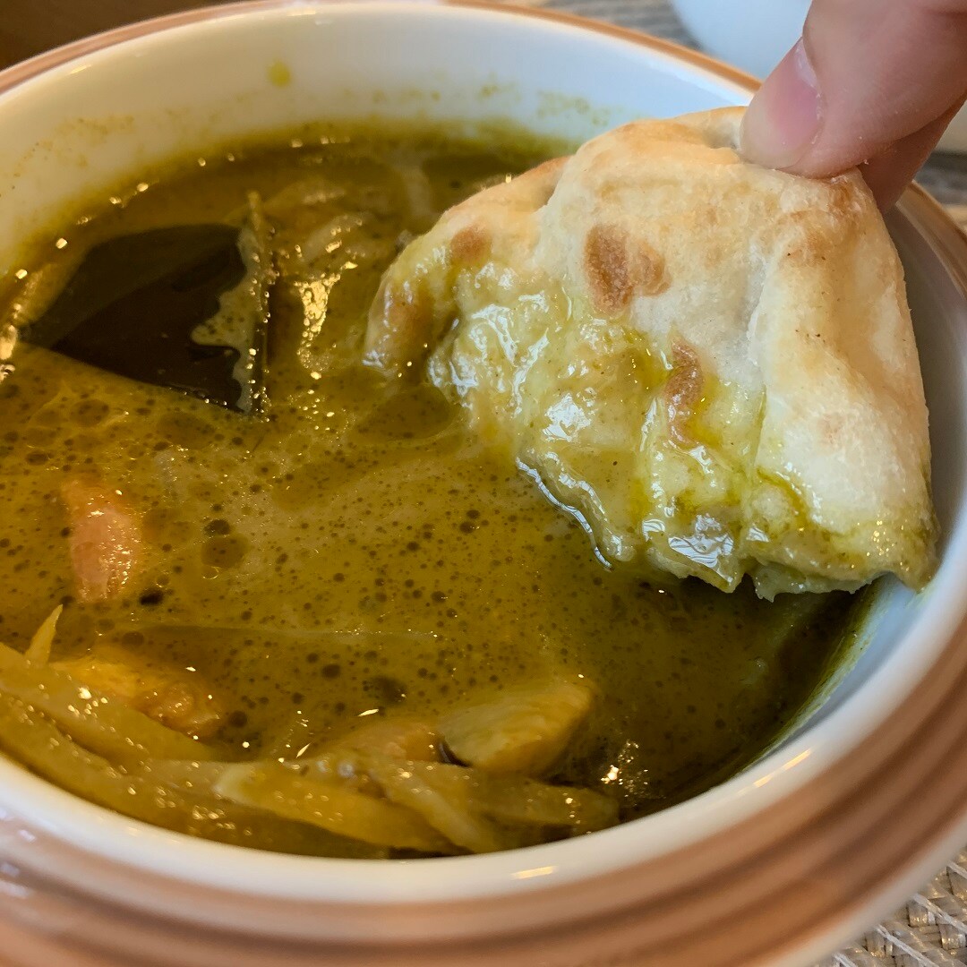 カレーにナンをつけている