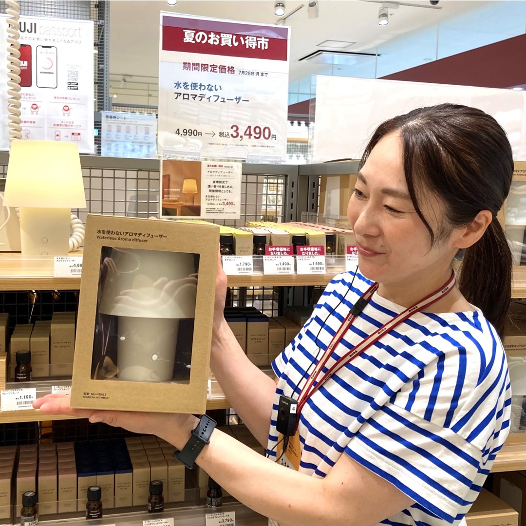 水を使わないアロマディフューザーを持つスタッフの写真です。
