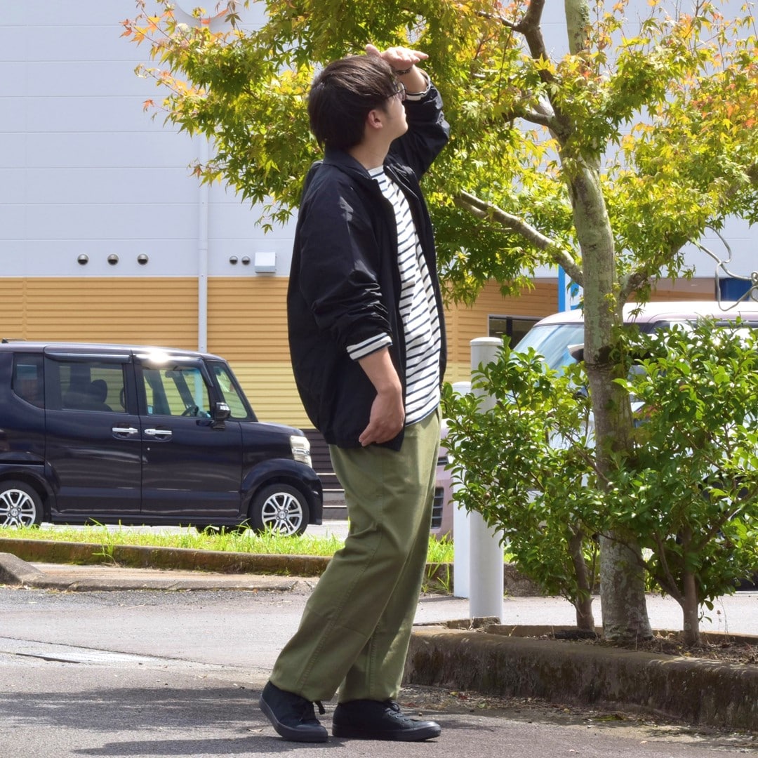 撥水ポケッタブルウィンドブレーカーとボートネック九分袖Tシャツを合わせたコーディネートのスタッフです。
