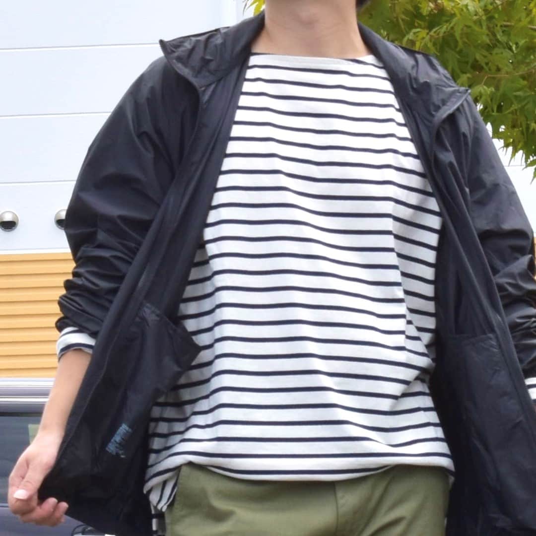 ポケッタブルウィンドブレーカーとボートネック九分袖Tシャツを合わせたコーディネートのスタッフです。