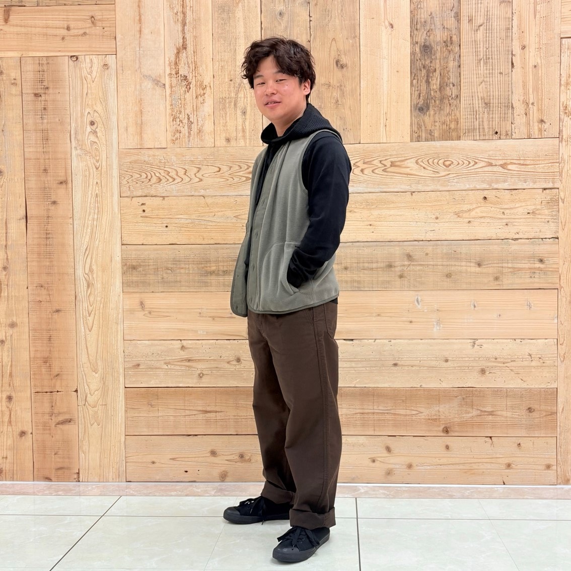 クルーネックセーターにフリースベストとバラクラバを合わせたコーディネートのスタッフ写真です。