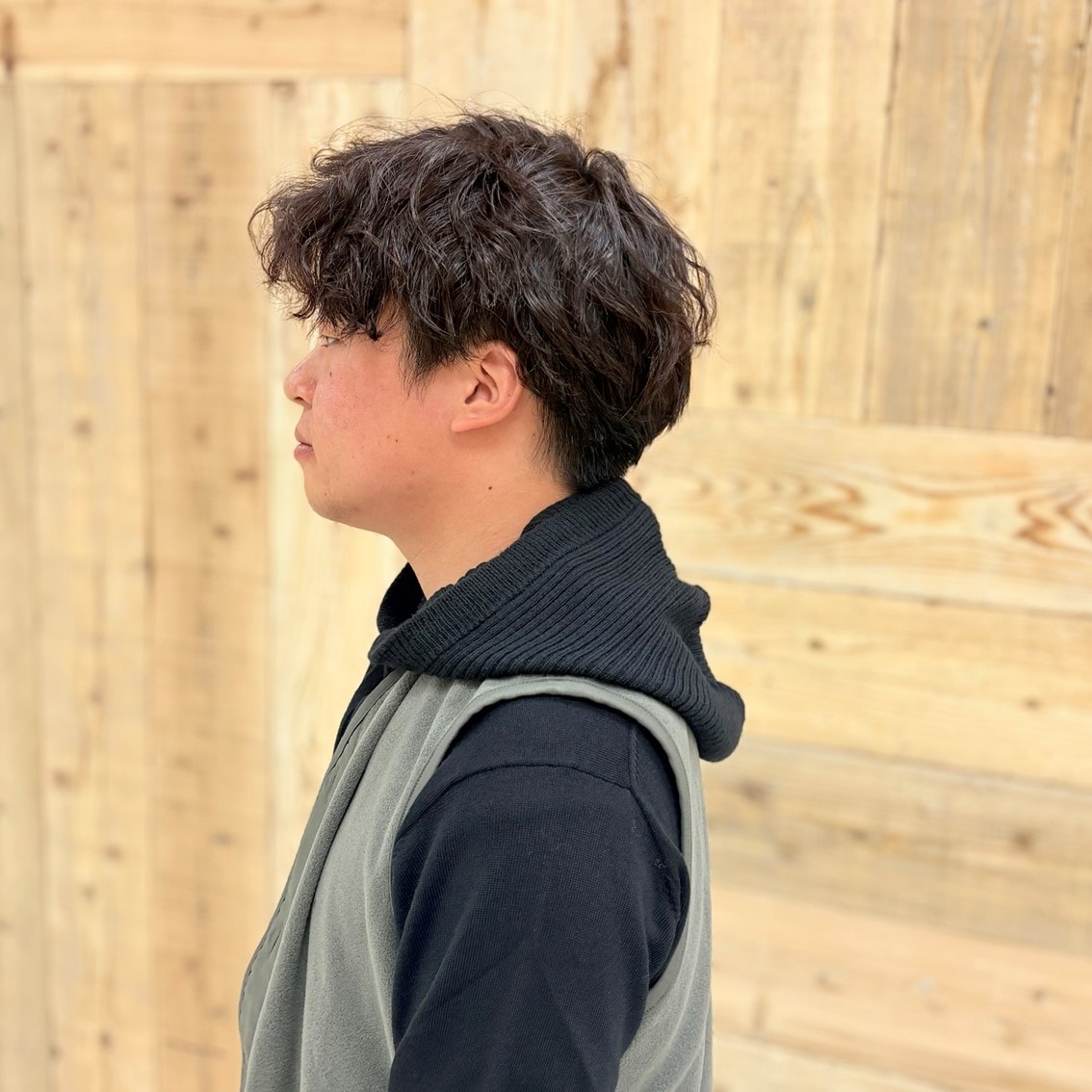 クルーネックセーターにフリースベストとバラクラバを合わせたコーディネートのスタッフ写真です。