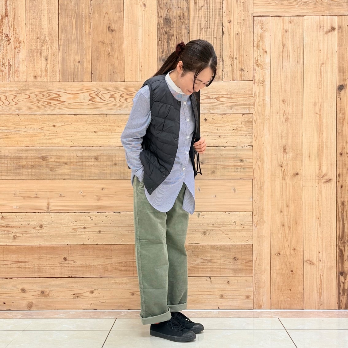 コーデュロイパンツにスタンドカラーロングシャツ、ベストを合わせたコーディネートのスタッフ写真です。