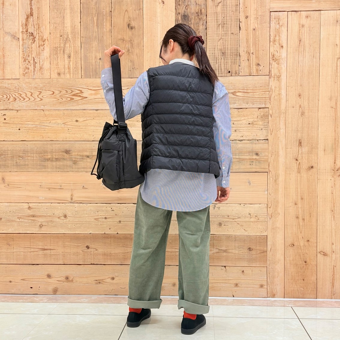 コーデュロイパンツにスタンドカラーロングシャツ、ベストを合わせたコーディネートのスタッフ写真です。