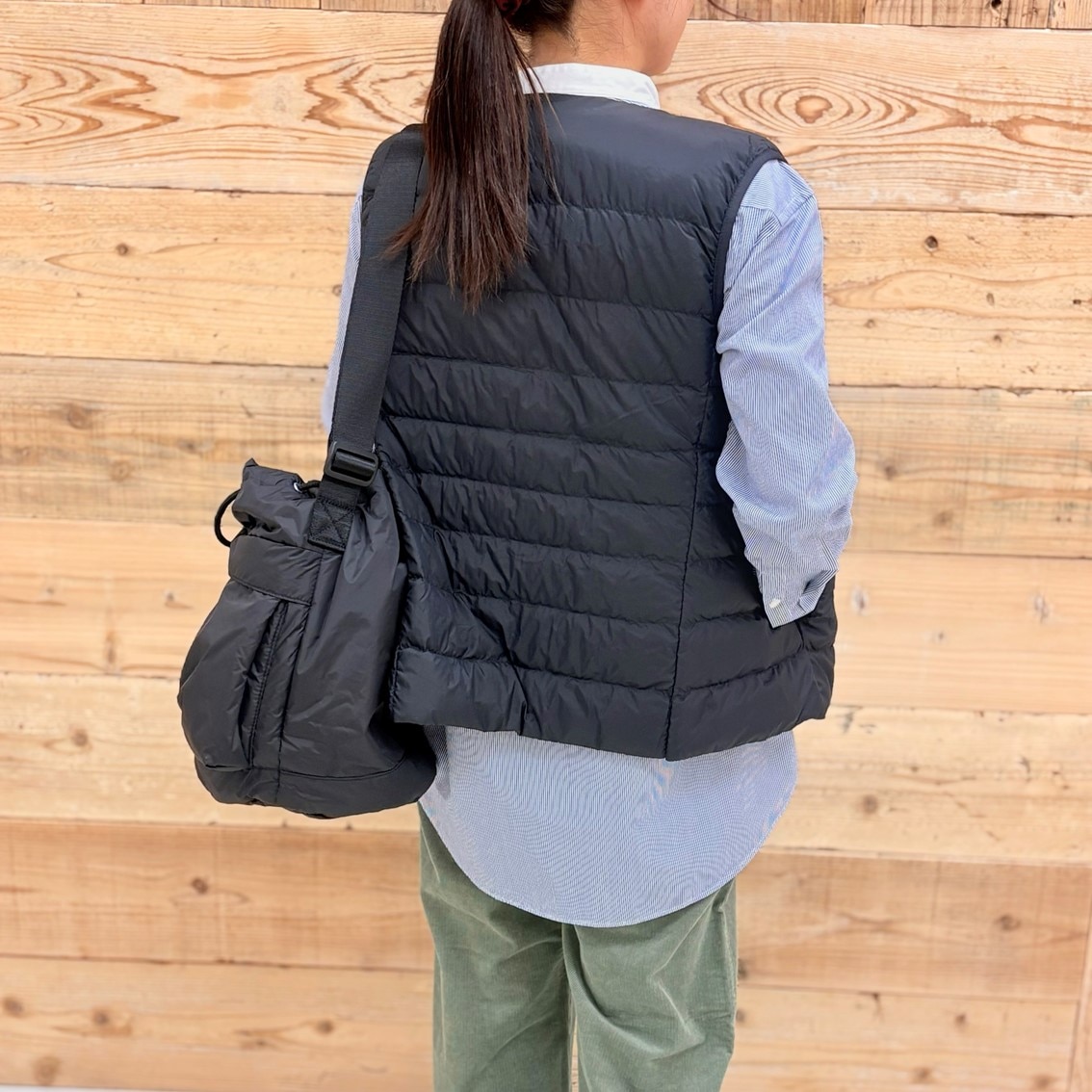 コーデュロイパンツにスタンドカラーロングシャツ、ベストを合わせたコーディネートのスタッフ写真です。