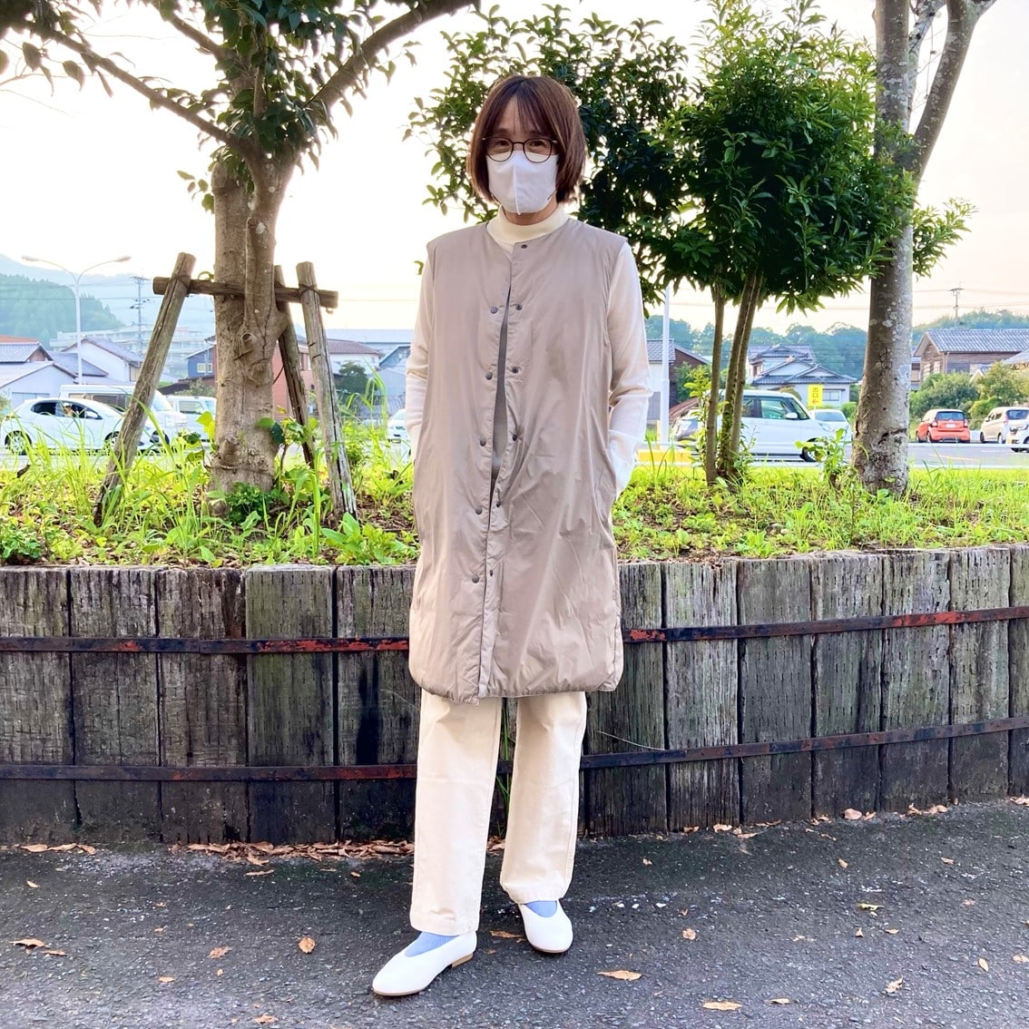 ハイネックセーターにノーカラーロングベストを合わせたコーディネートのスタッフ写真です。