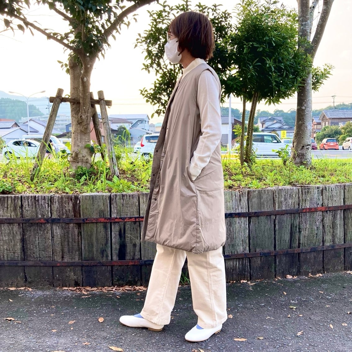 ハイネックセーターにノーカラーロングベストを合わせたコーディネートのスタッフ写真です。