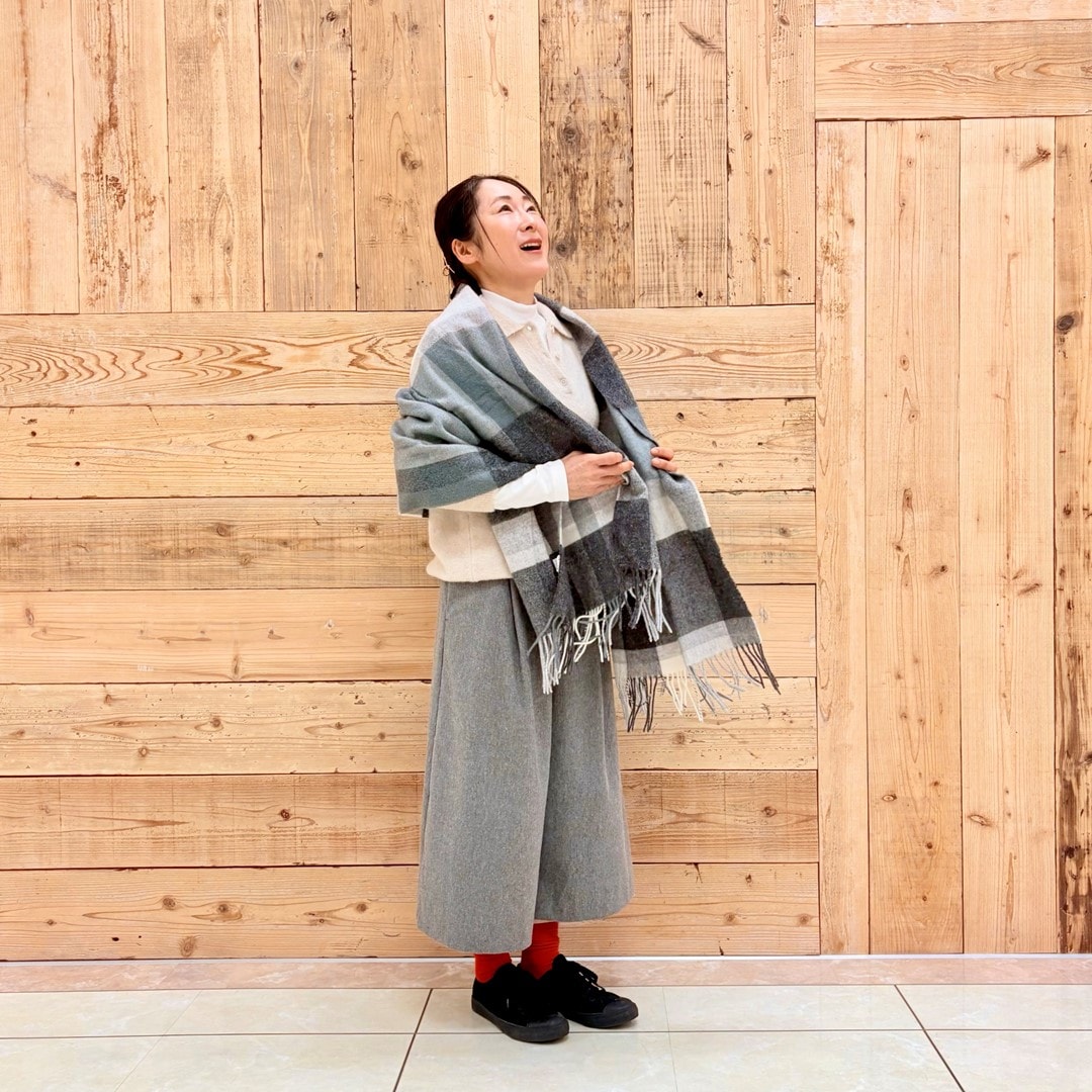 ブークレニットポロにストールを合わせたコーディネートしたスタッフの写真です。