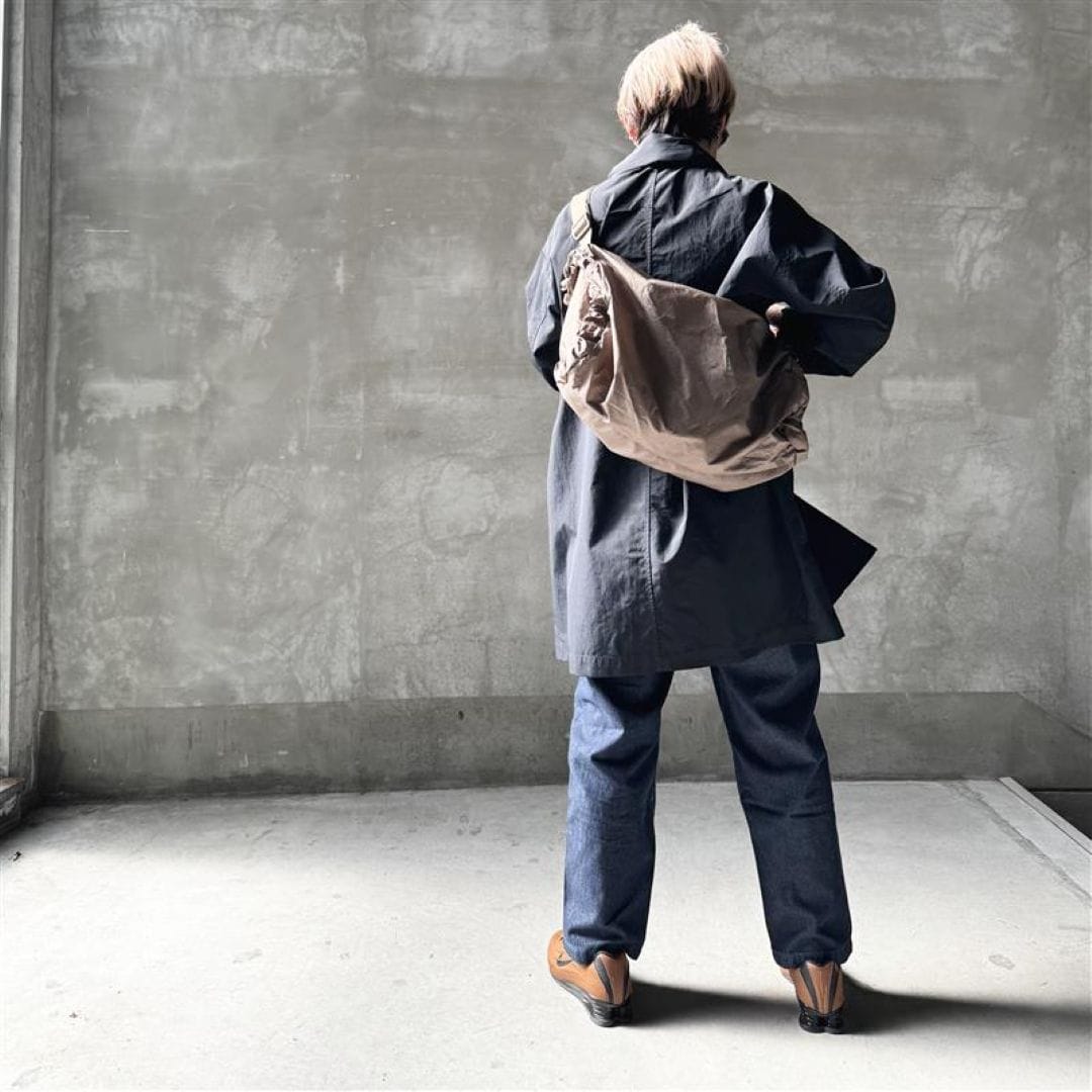 デニムにコートを羽織った女性の後ろ姿