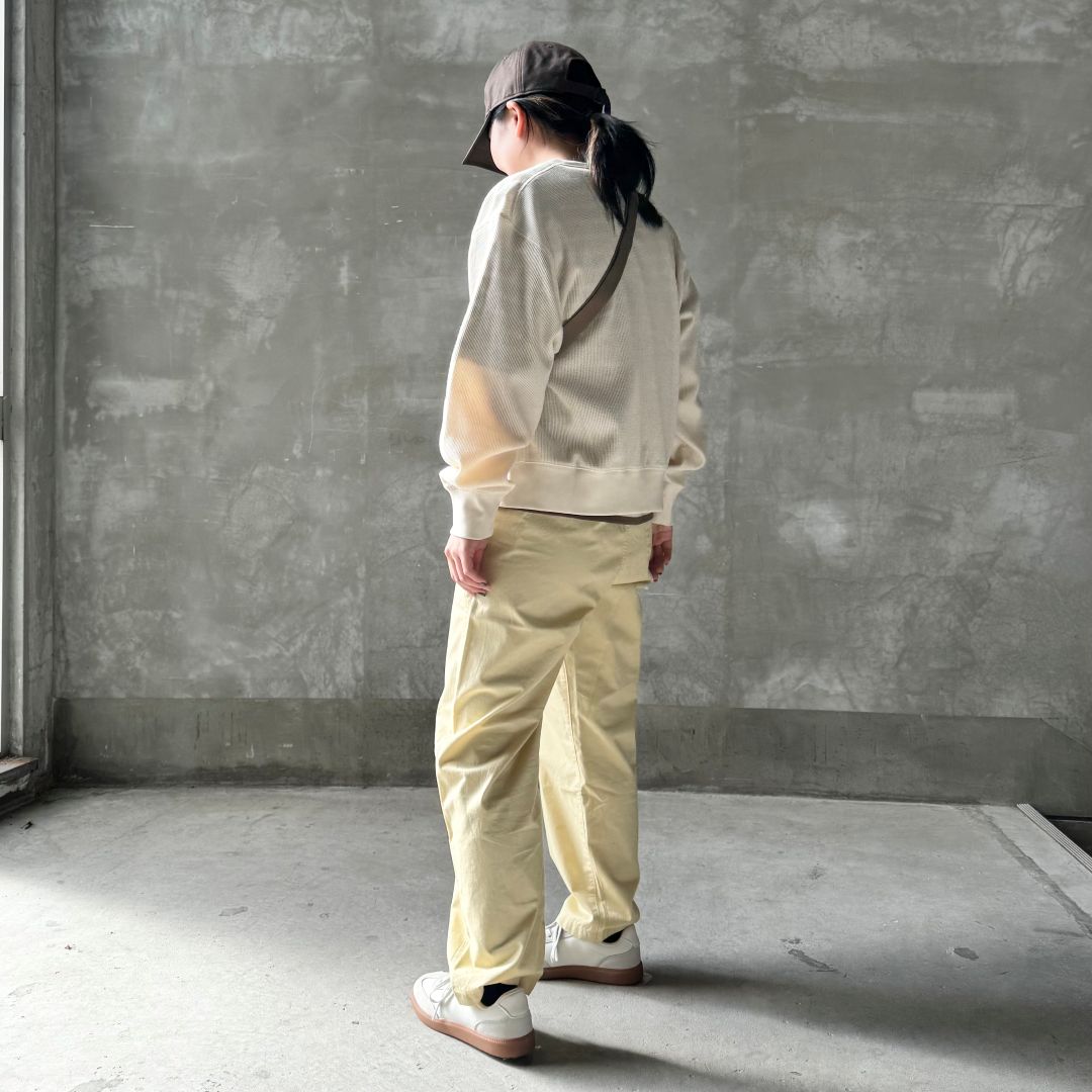 黄色のパンツをはいた女性の後ろ姿の画像