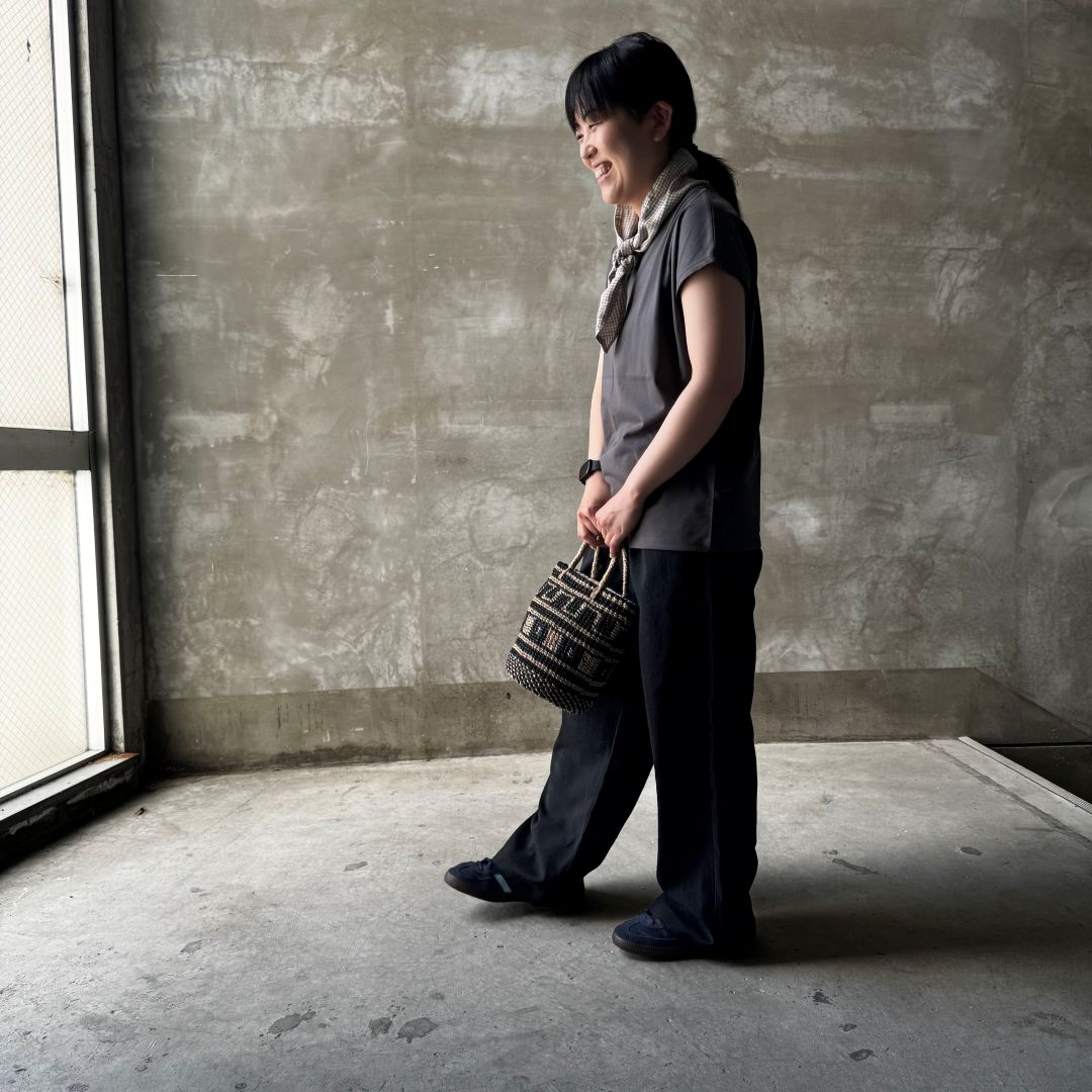 黒いパンツをはいた女性の横向き画像