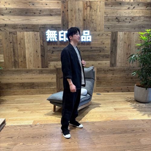 リネン生地のセットアップを着て立つ男性