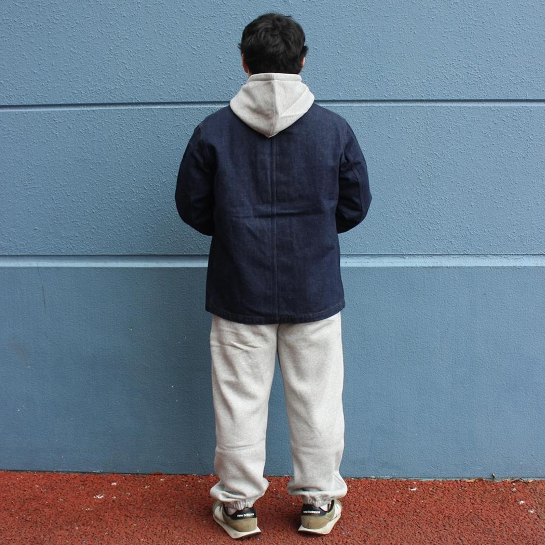 スウェットのセットアップにデニムのカバーオールを着たのを後ろから撮った写真