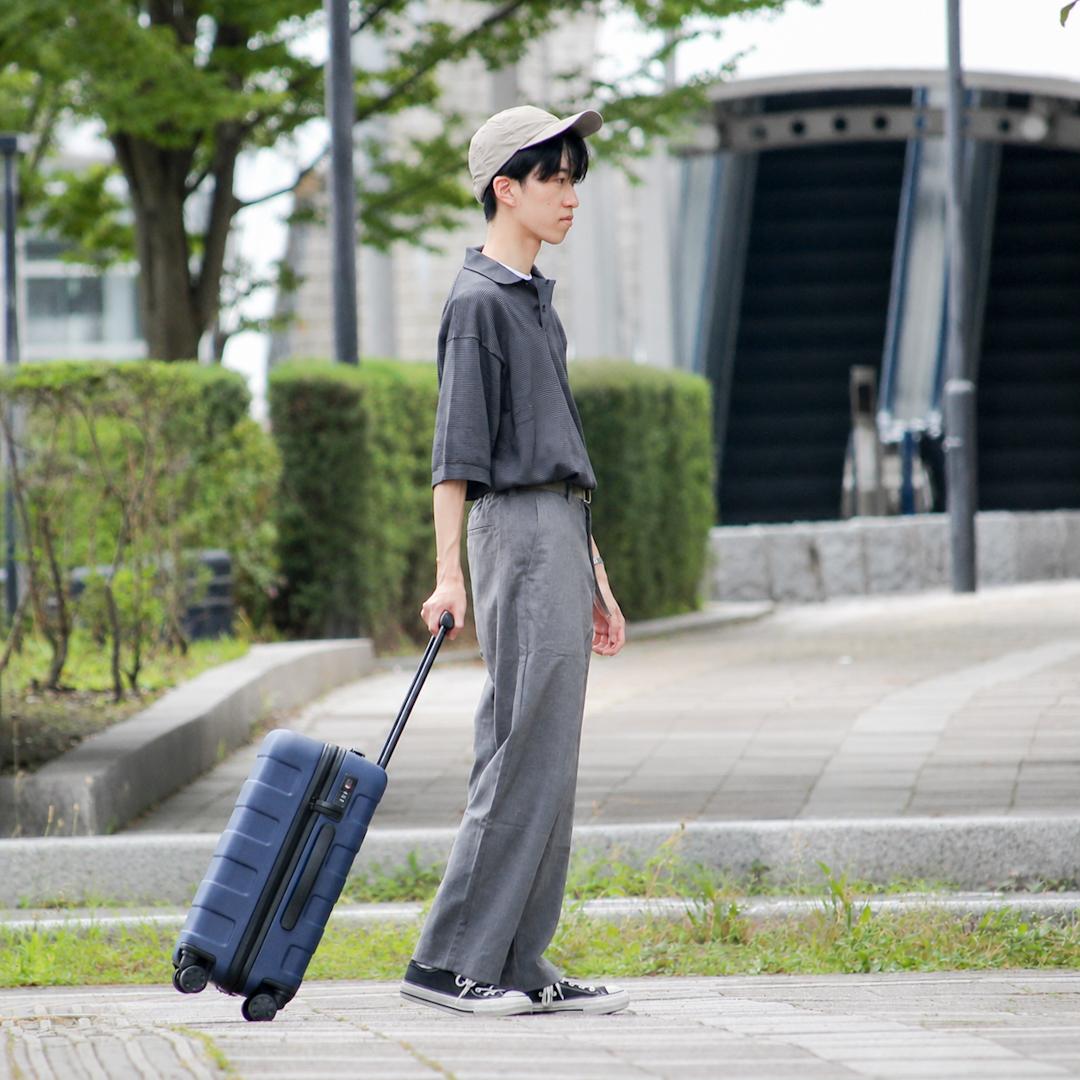 キャリーケースをもって歩いている写真です