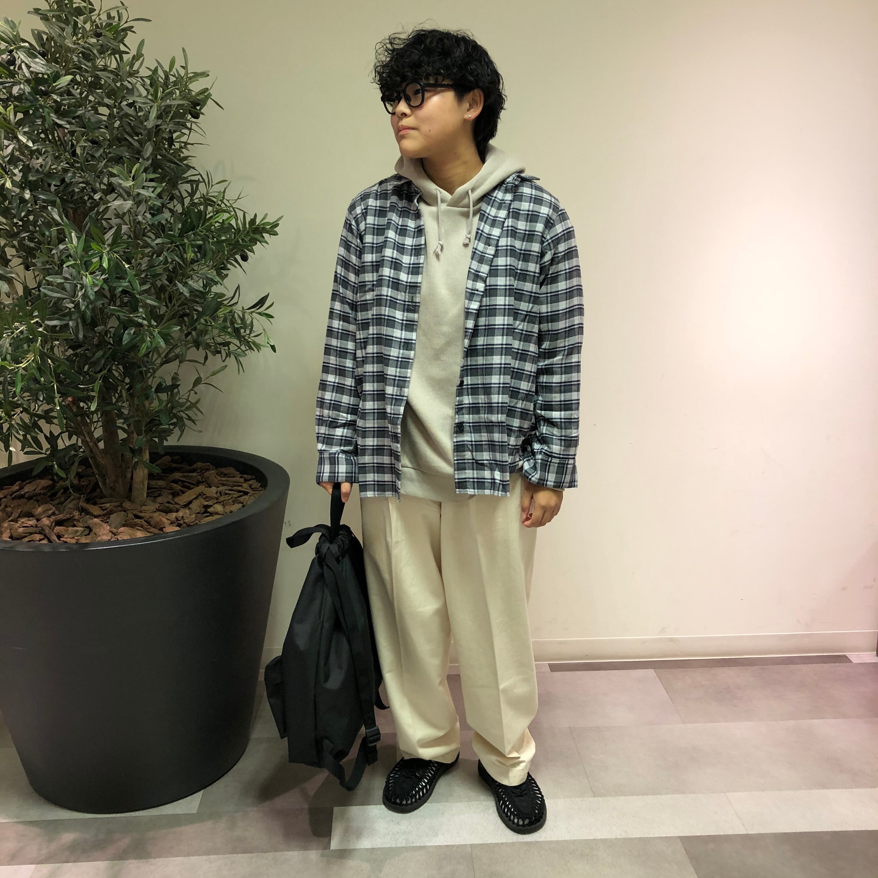 フランネルシャツを着た女性スタッフが立っている写真