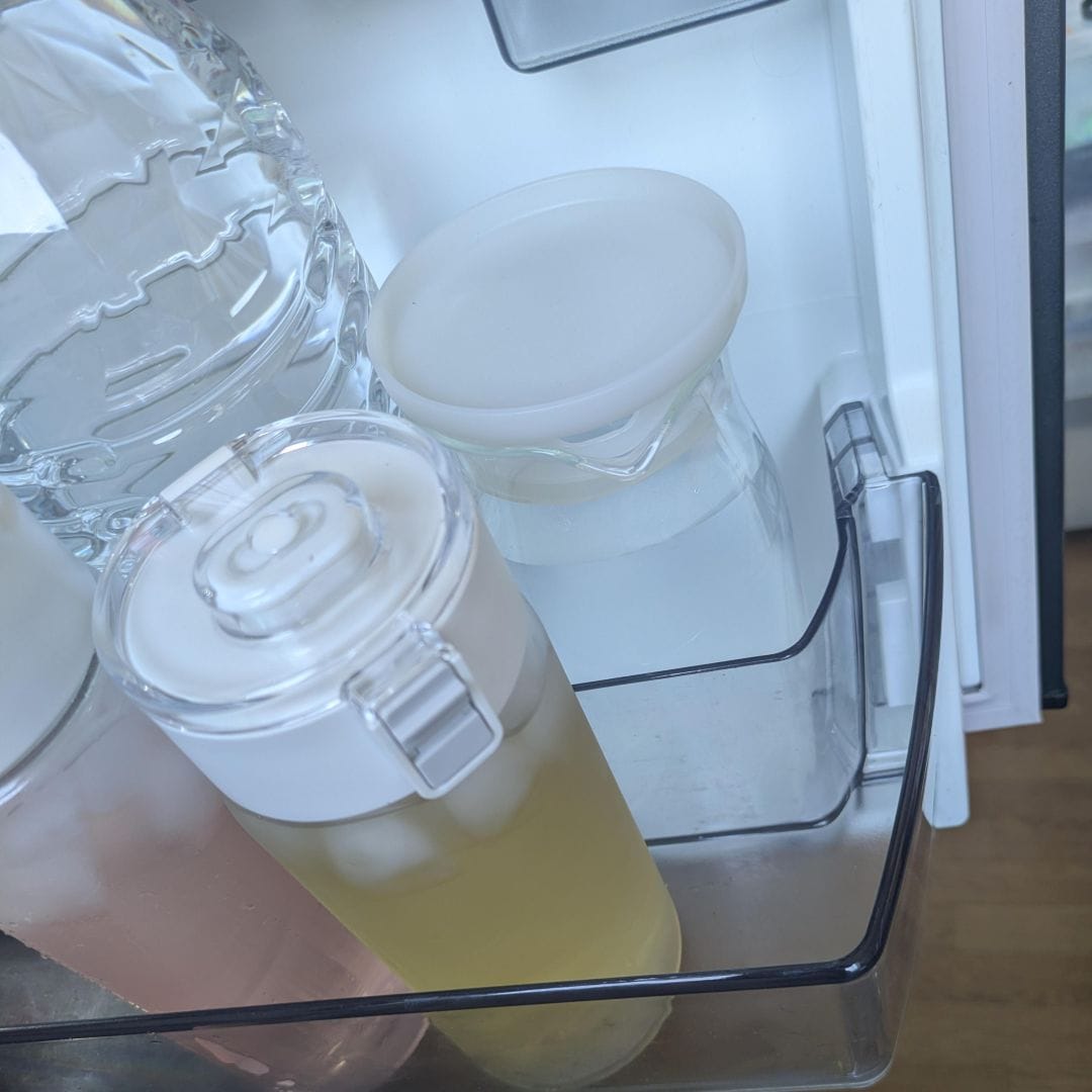 テーブルにコップとドリンクの入った容器の写真