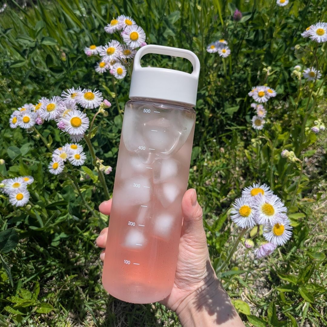 花の背景にピンク色のアセロラのドリンクの写真