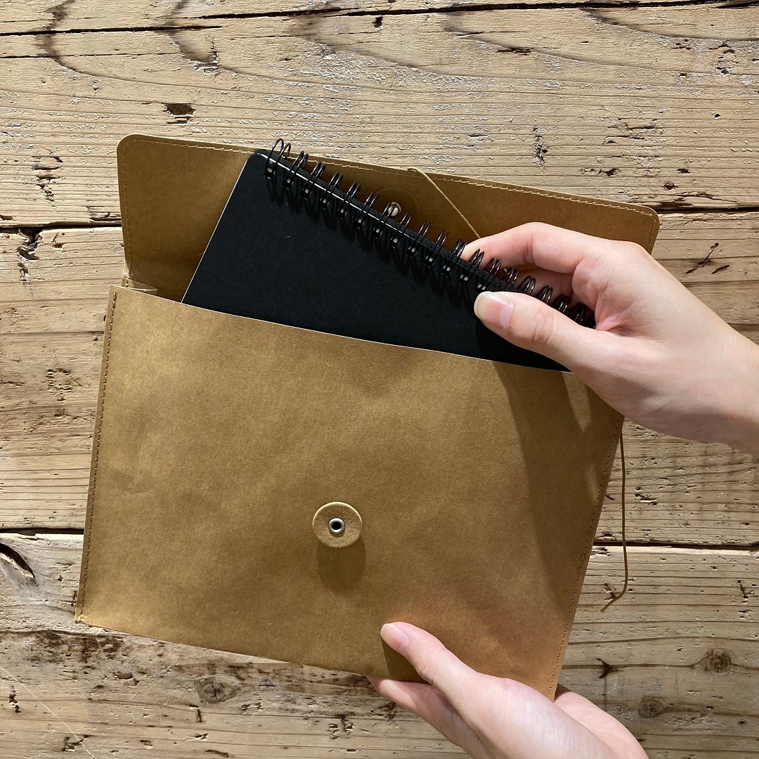 書類ケースにノートを入れている写真