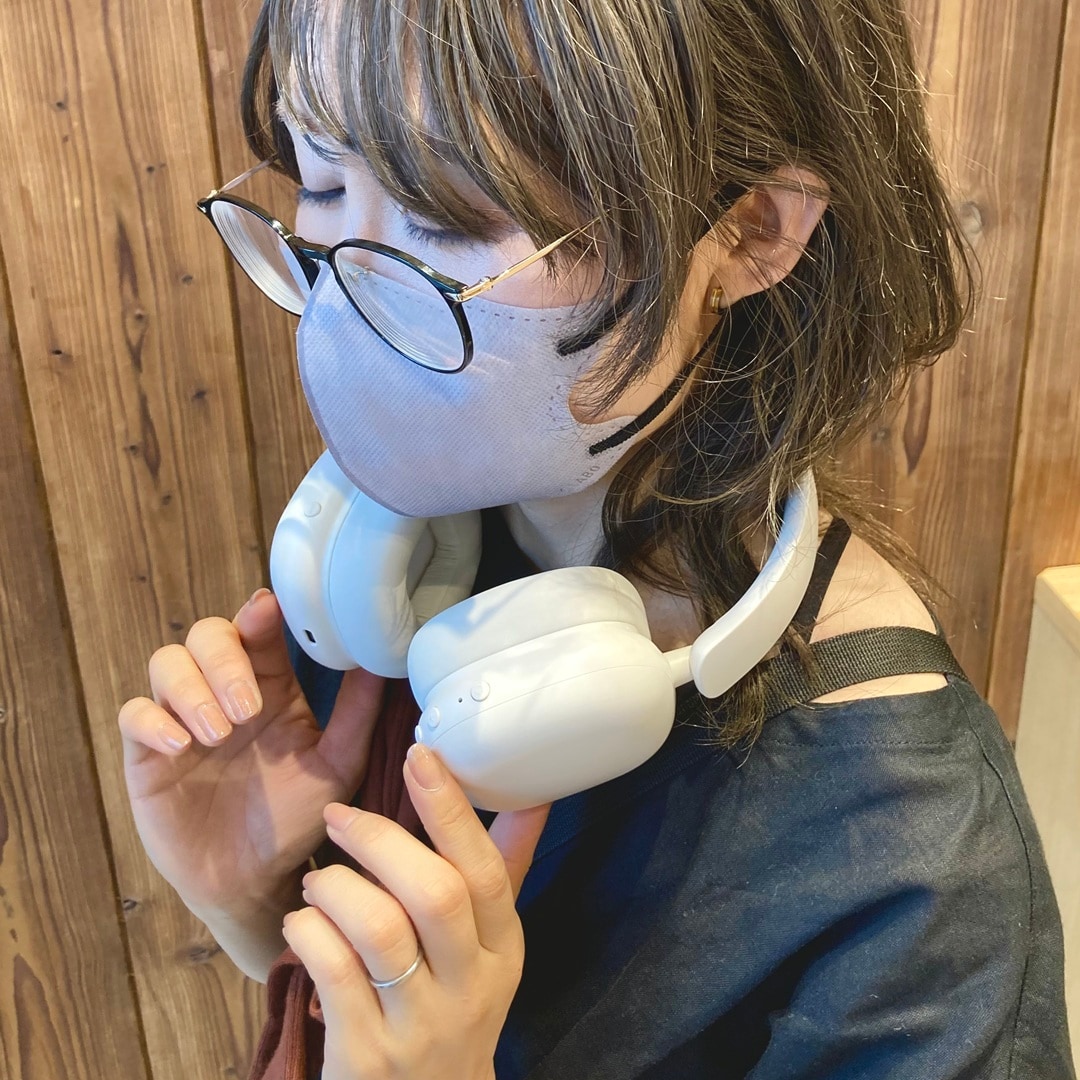 人がヘッドホンを首にかけている画像