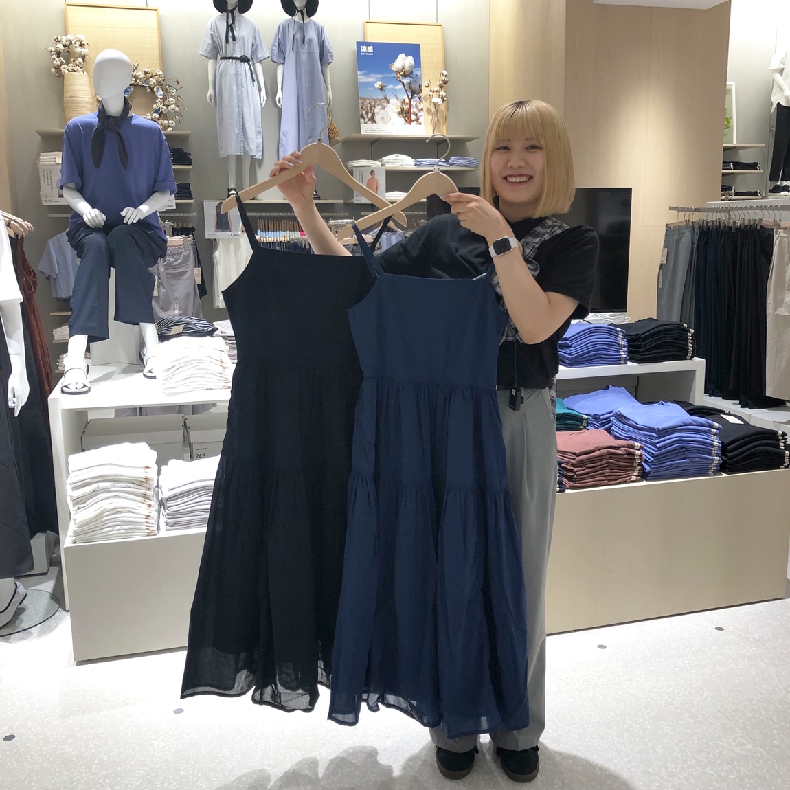 強撚ボイルワンピースを両手に持つスタッフ