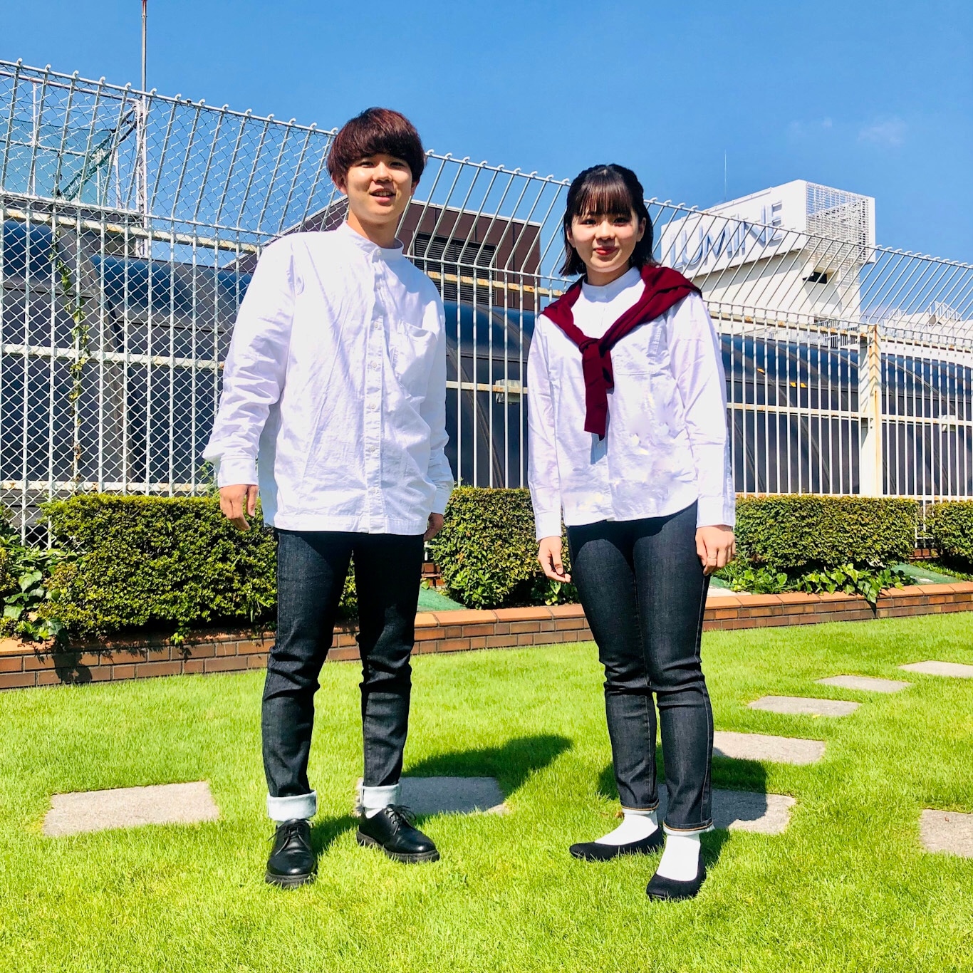 オックスの白いシャツにデニムを履いている男女スタッフ