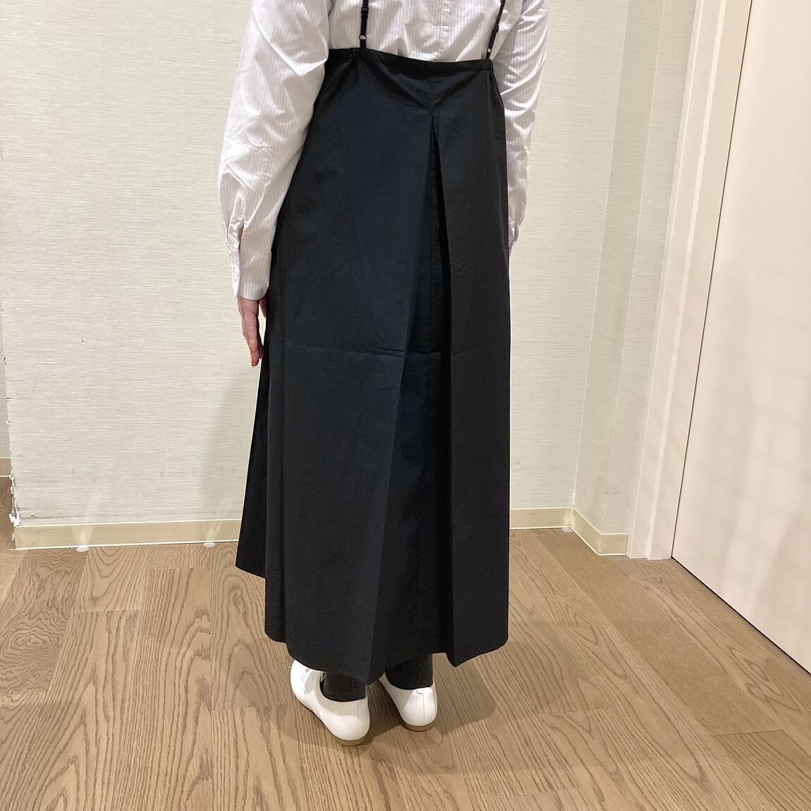 白のブラウスとくろのワンピースを着用した女性