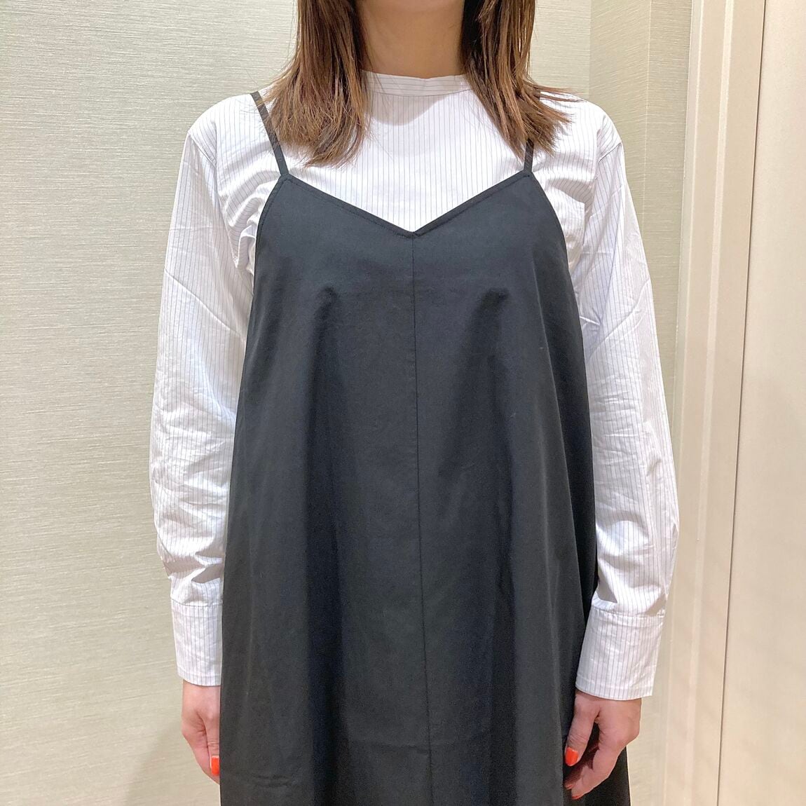 白のブラウスとくろのワンピースを着用した女性