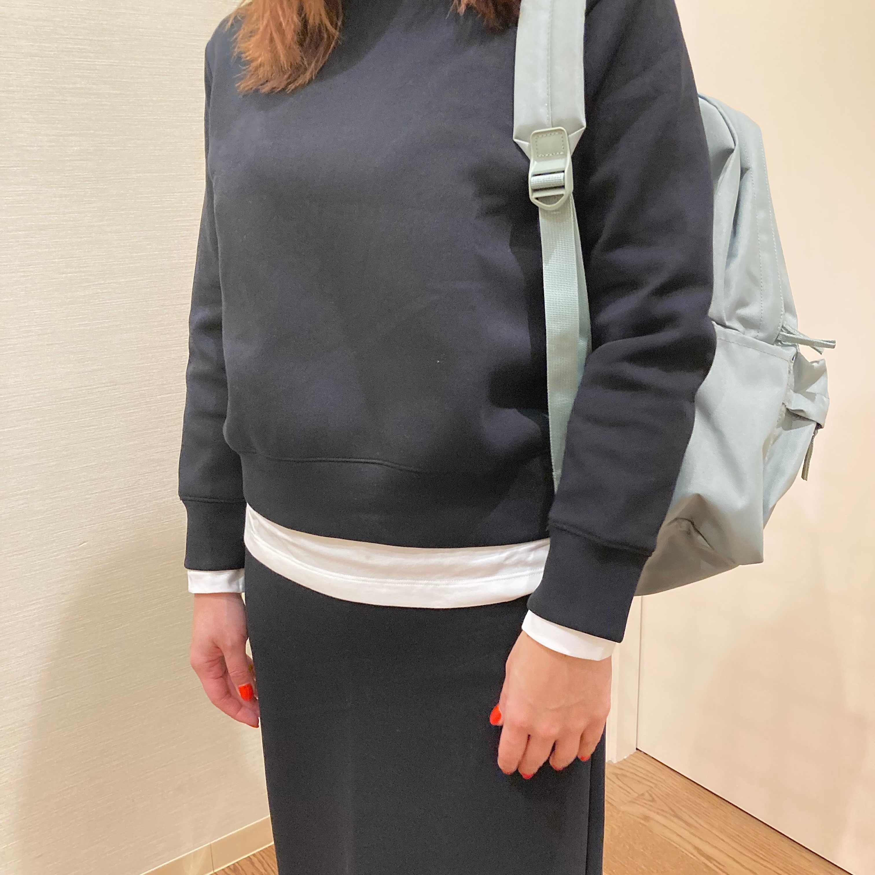 黒いスウェットのトップスとスカートを着用した女性