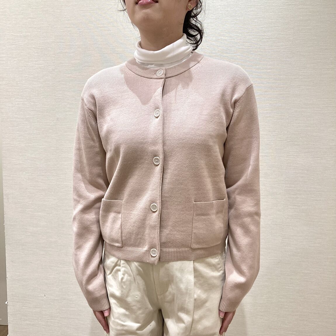 ピンクのカーディガンを着用した女性