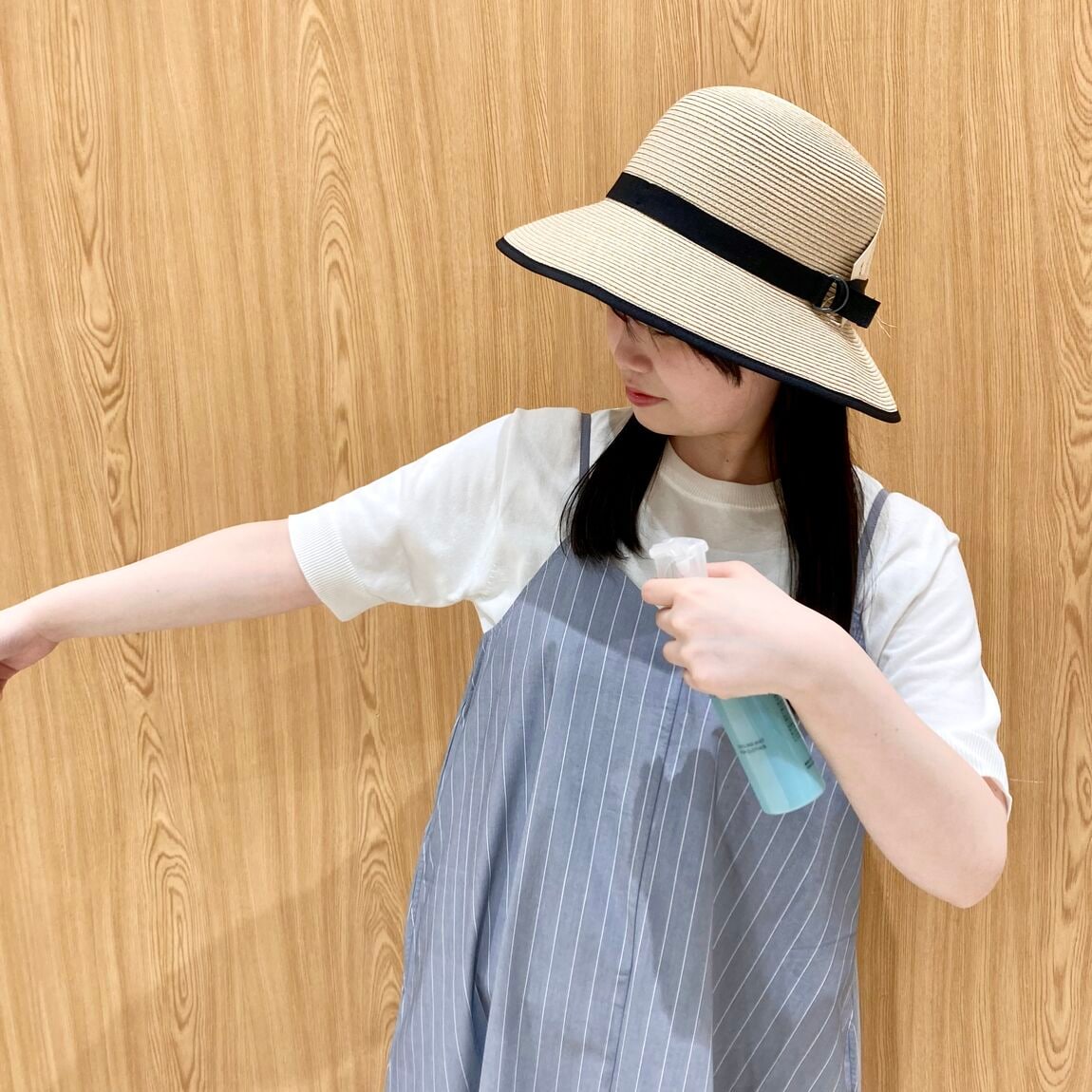 服の上からかける冷感スプレーを使う女性スタッフ