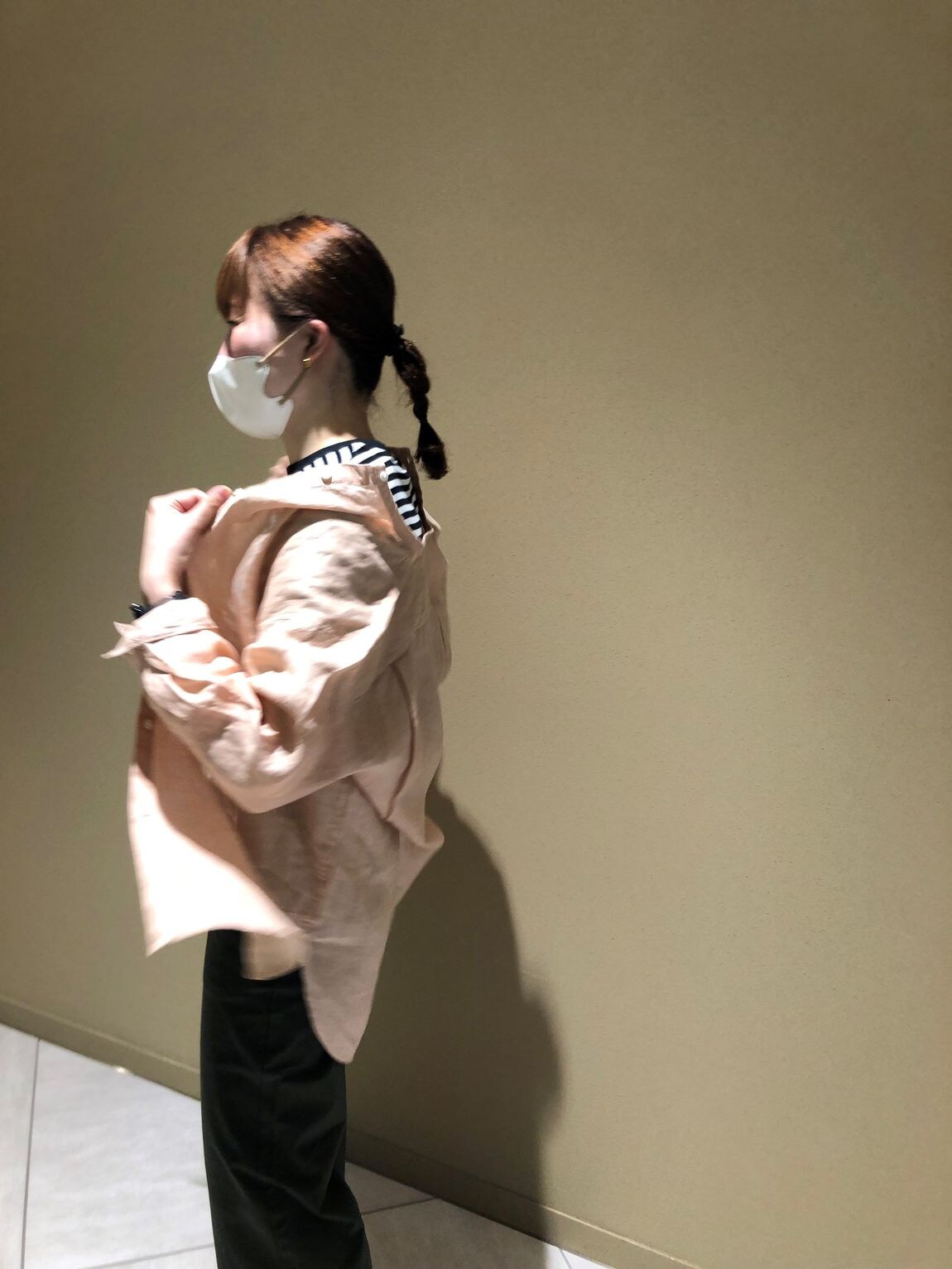 リネンシャツを羽織った後ろ姿の女性スタッフ