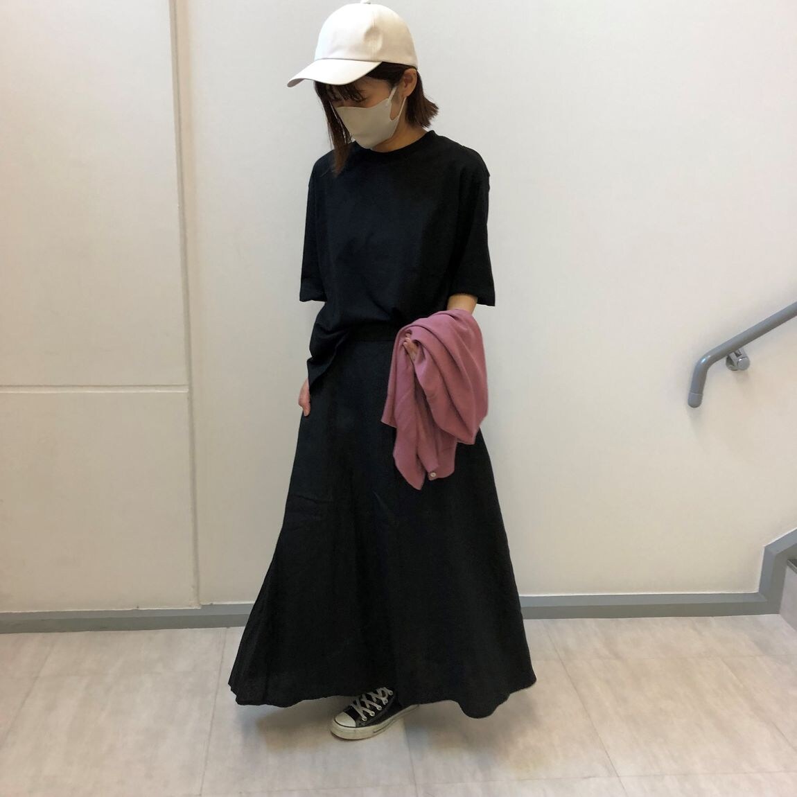 カーディガンを手に持つ女性スタッフ