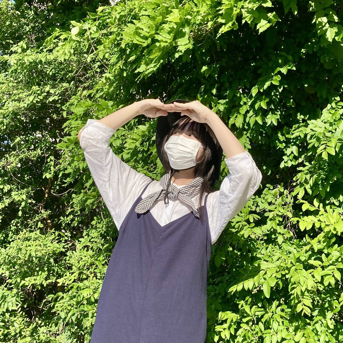 草むらの中で空を見上げる女性スタッフ