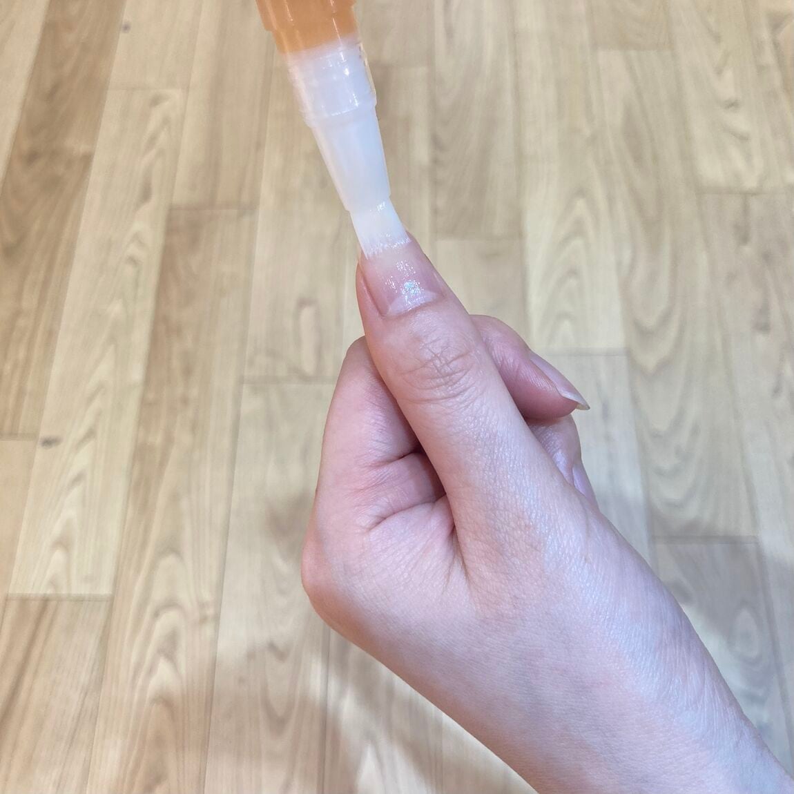 爪にネイルケアオイルを塗布する写真