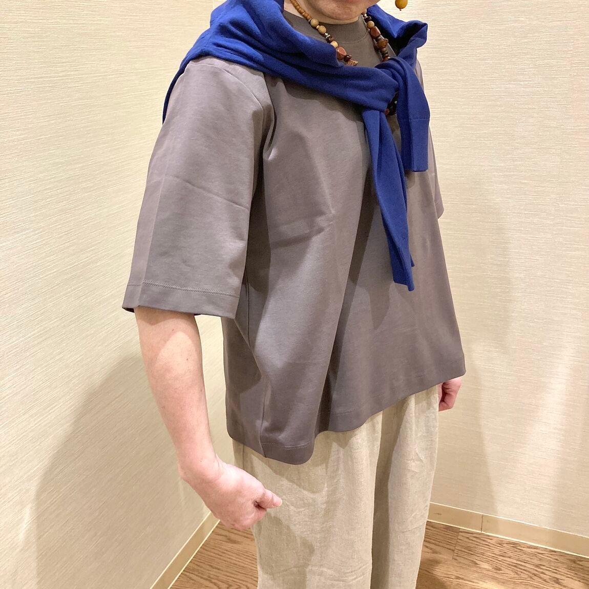 グレーのTシャツとベージュのパンツを着用した女性
