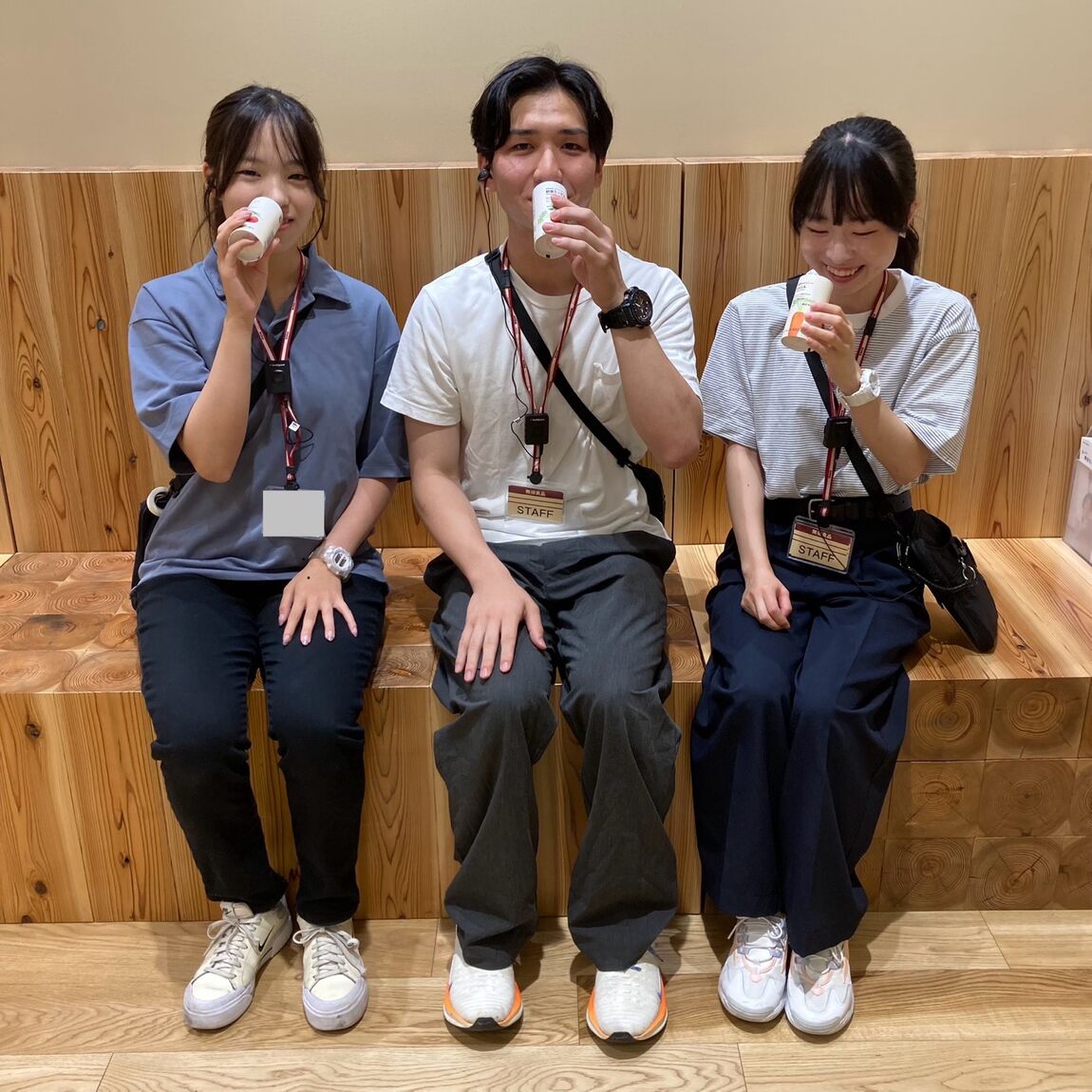 「国産野菜１００％ジュース」を飲みながら談笑する3人のスタッフの画像