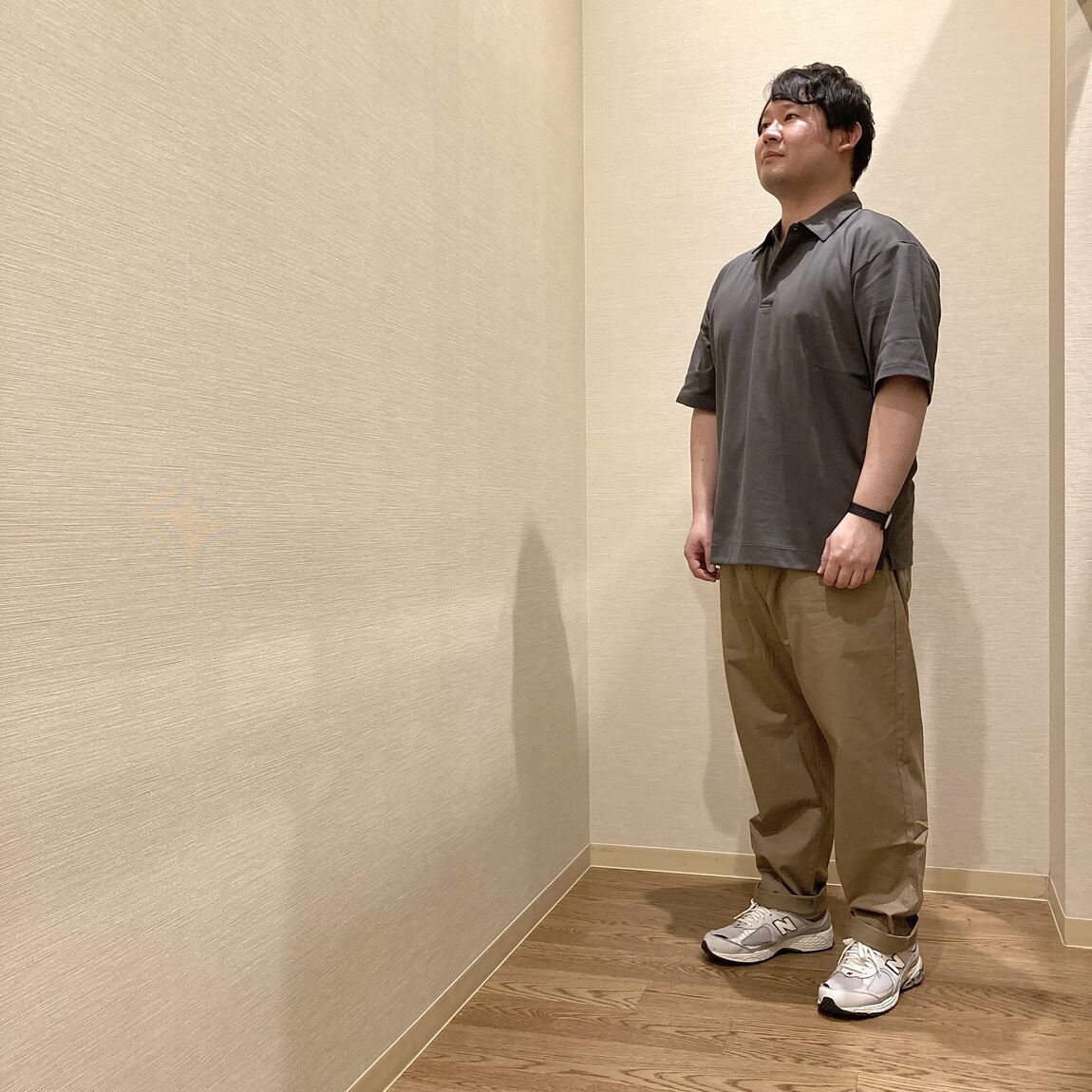 グレーのTシャツとベージュのパンツを着用した女性