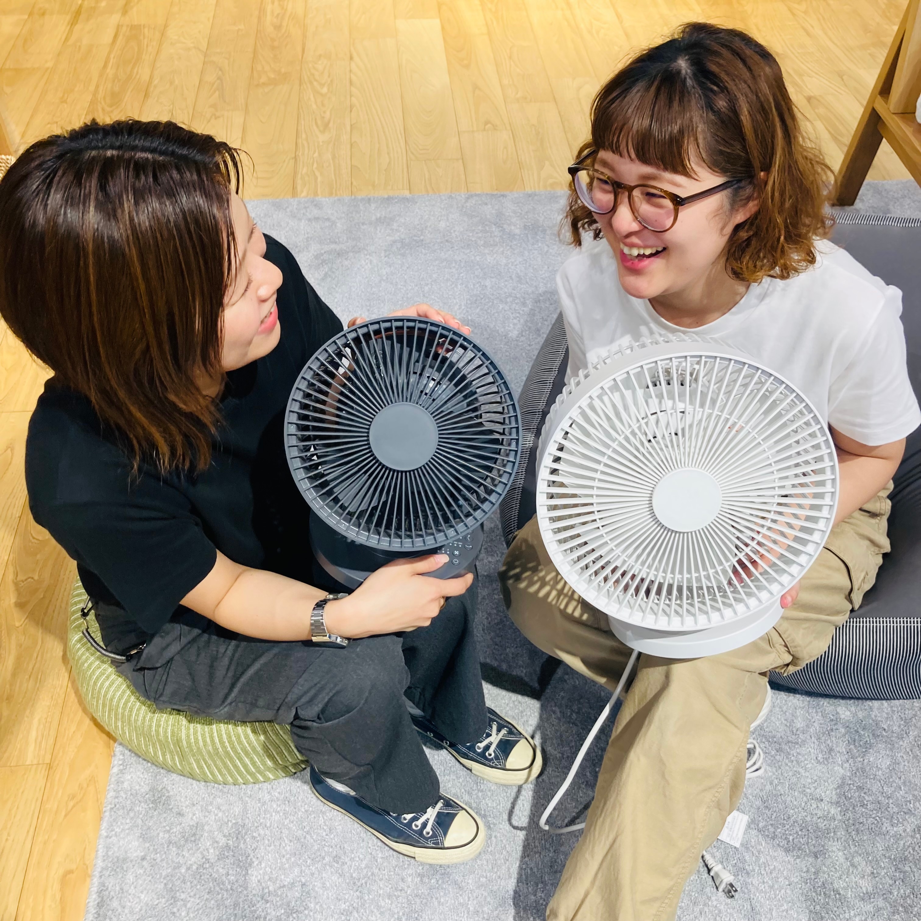 2人のスタッフが座ってサーキュレター持ってる