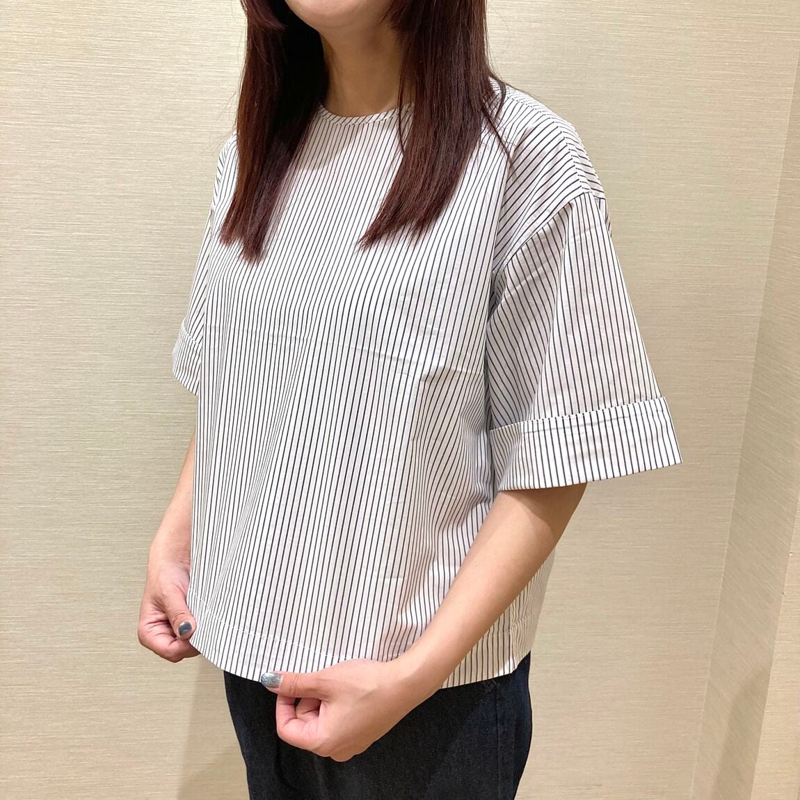 ストライプのブラウスにデニムのイージーパンツを着用した女性