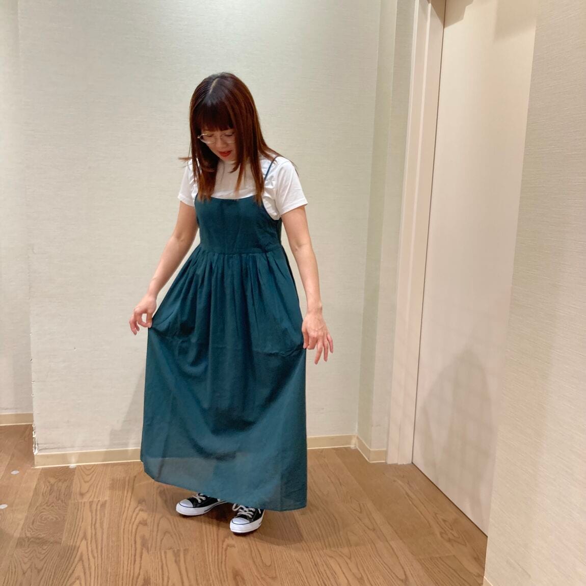 グリーンのキャミソールワンピースを着用した女性