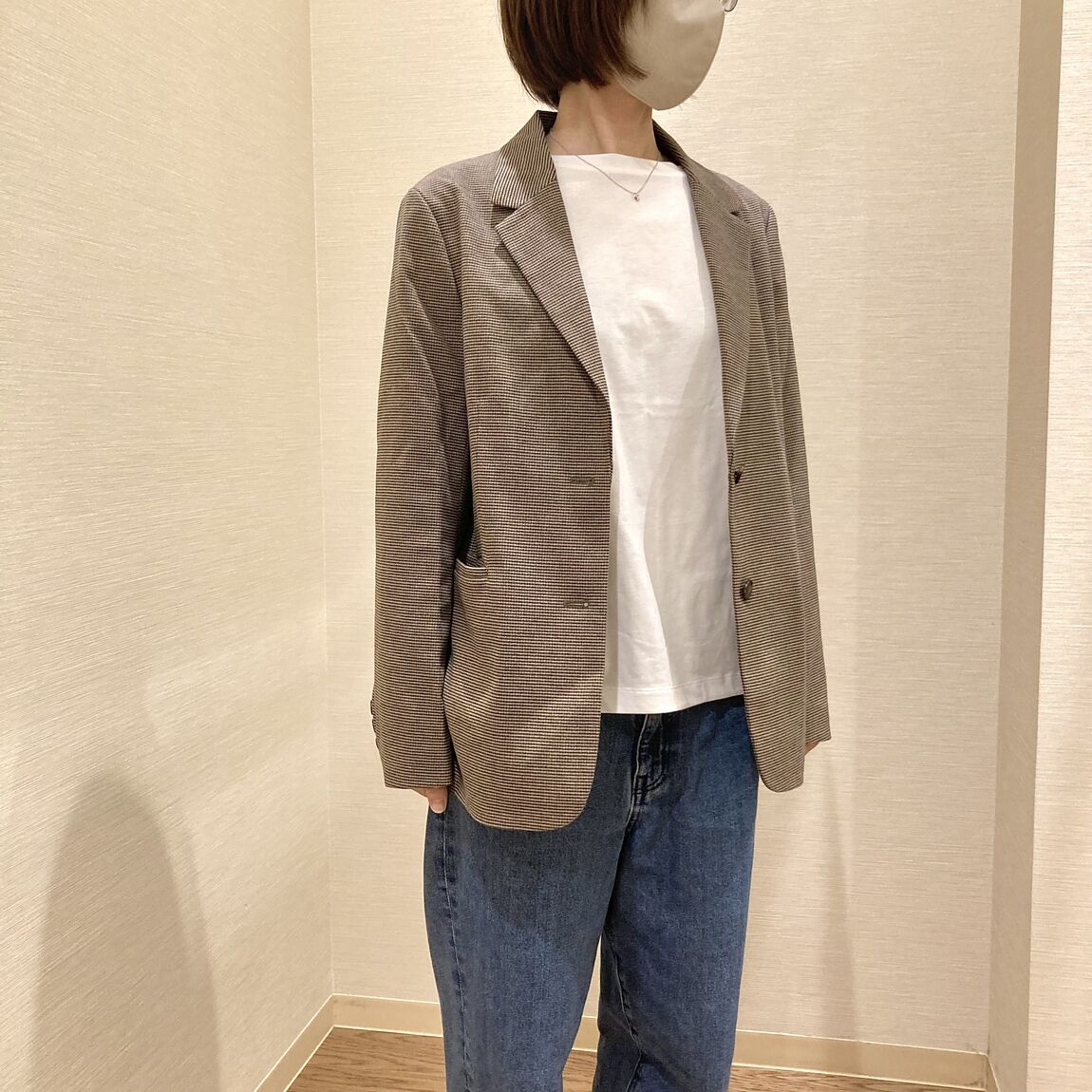 ジャケットにデニムパンツを着用した女性