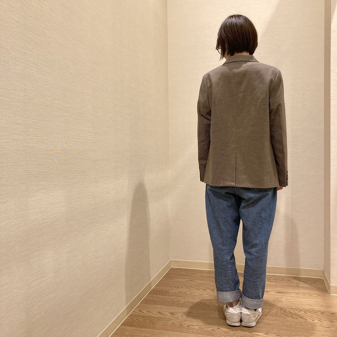 ジャケットにデニムパンツを着用した女性