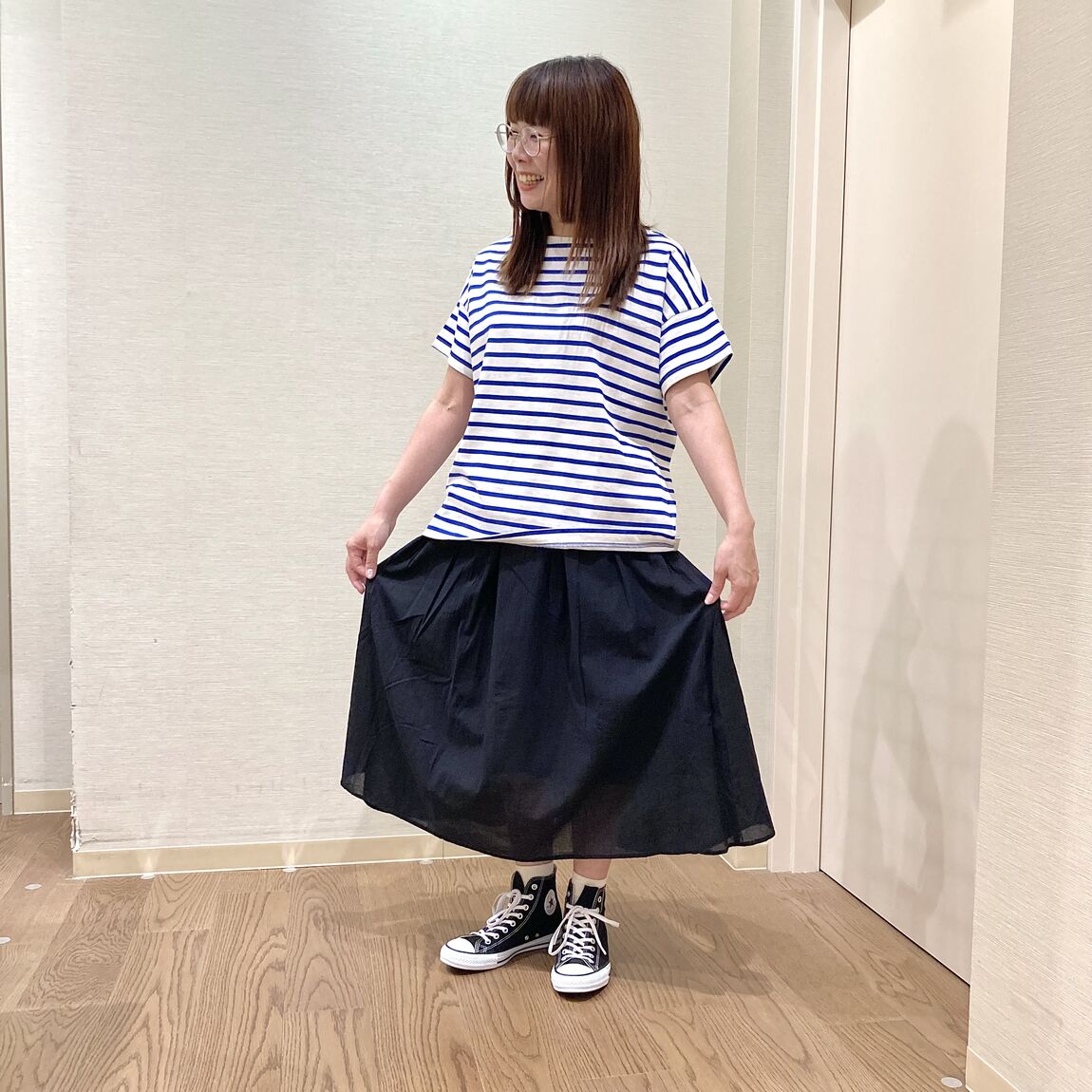 ボーダーのTシャツと黒のスカートを着用した女性