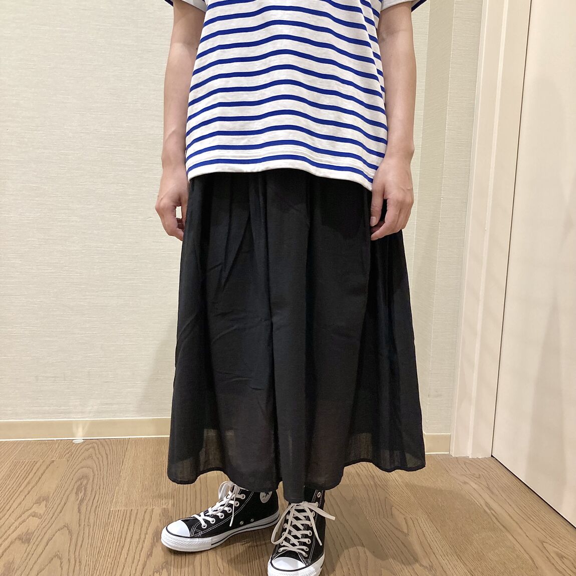 ボーダーのTシャツと黒のスカートを着用した女性