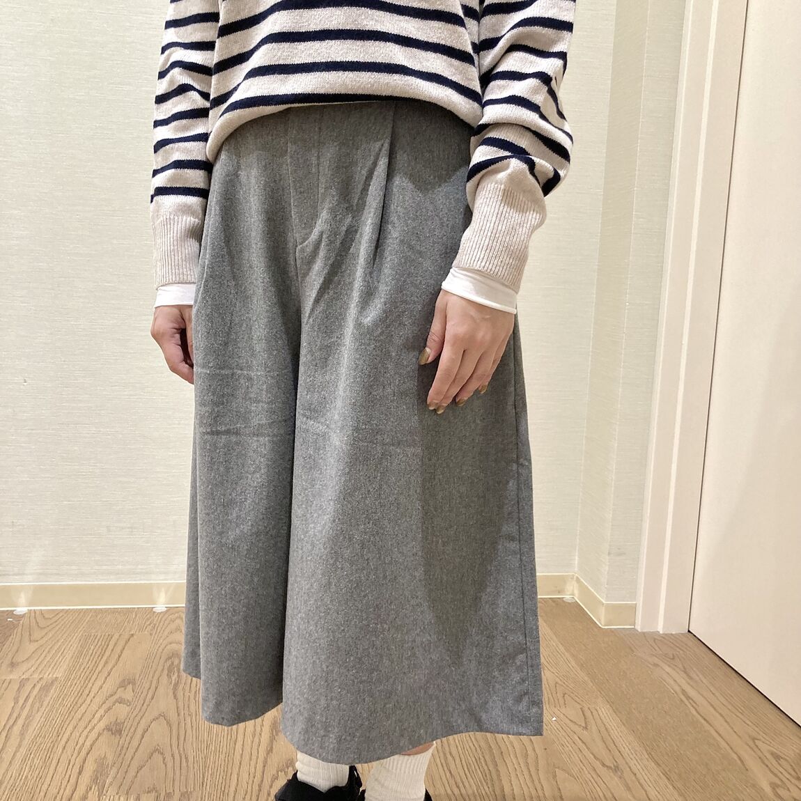 ボーダーのニットとキュロットスカートを着用した女性